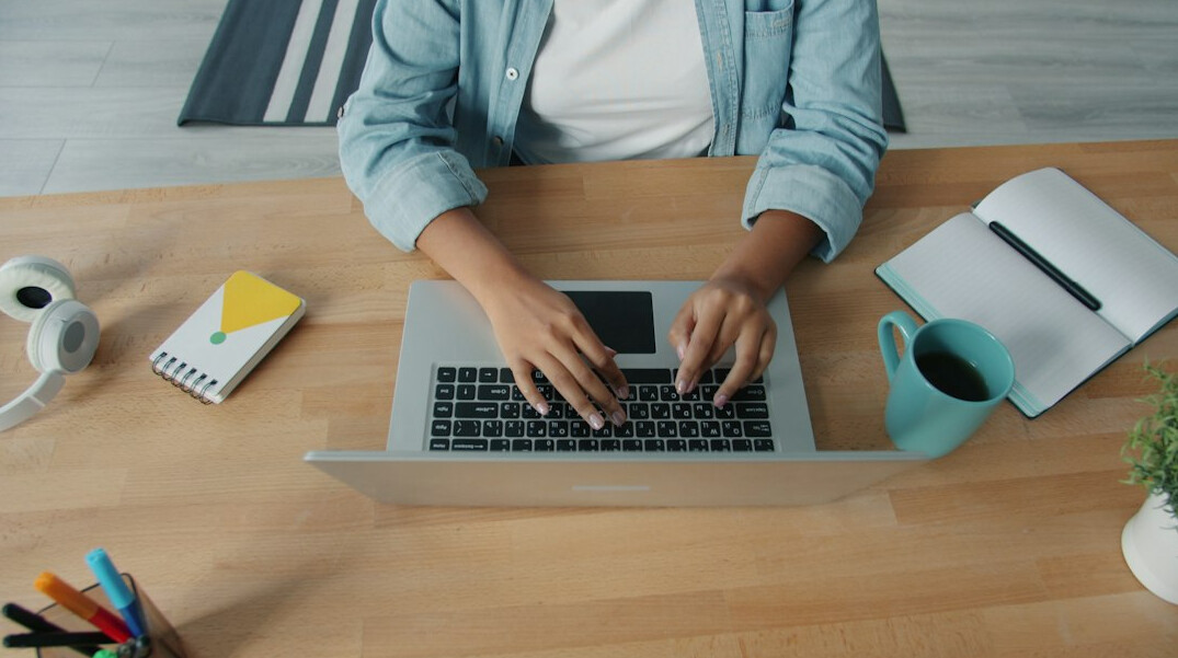 writer typing on laptop at desk
